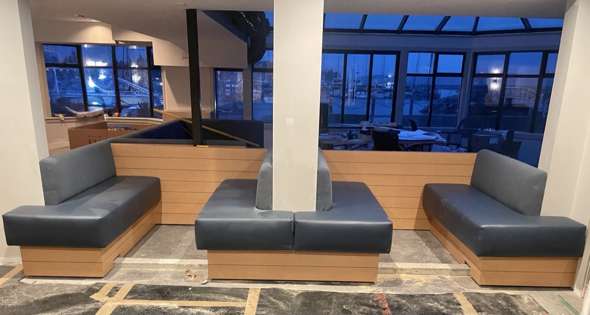 Grey vinyl bench modules with light wood bases in a lounge with dark night windows